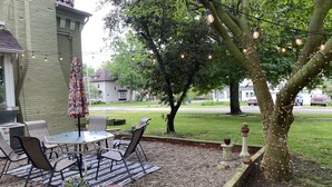 Un patio esterno con tavolo, sedie e un tappeto a righe.