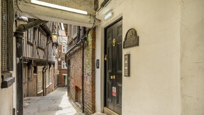 Ein schmaler Gang mit einer schwarzen Tür, auf der 'ROWNTREE HOUSE 10 PAVEMENT' steht.