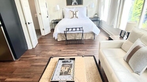 A modern bedroom with a bed, bedside tables, a sofa, and a coffee table. - Large, Charming historic flat, Downtown/Bourbon trail/Yum Center (Louisville)