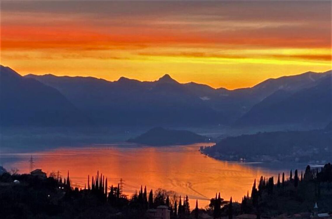 Un paisaje montañoso con un lago al atardecer.