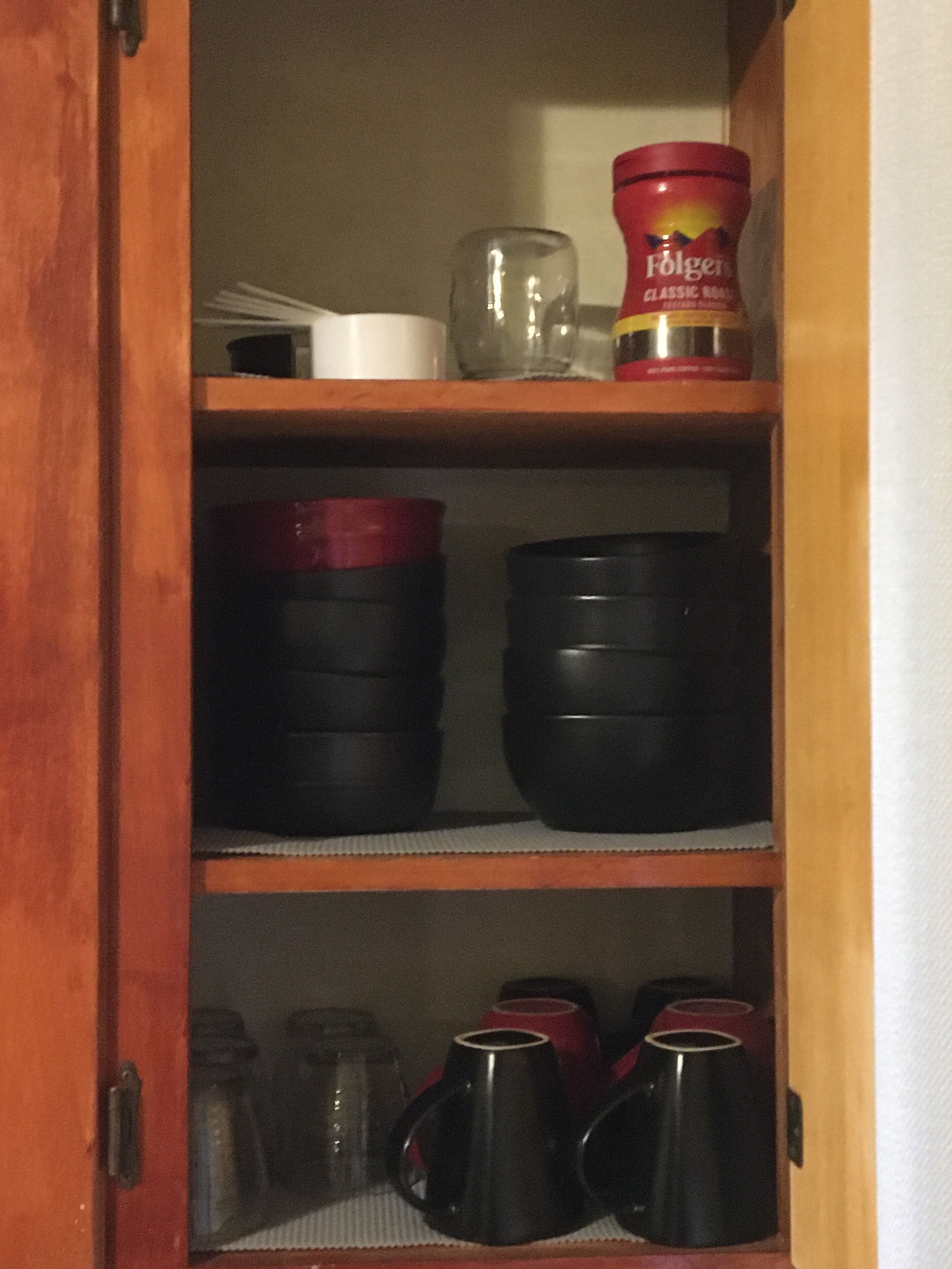 Un pensile cucina con ripiani che contengono diversi utensili da cucina.