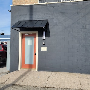 Stylish entrance with a red-framed door and black awning.