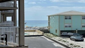 A building with a flat roof and a balcony with metal railings.