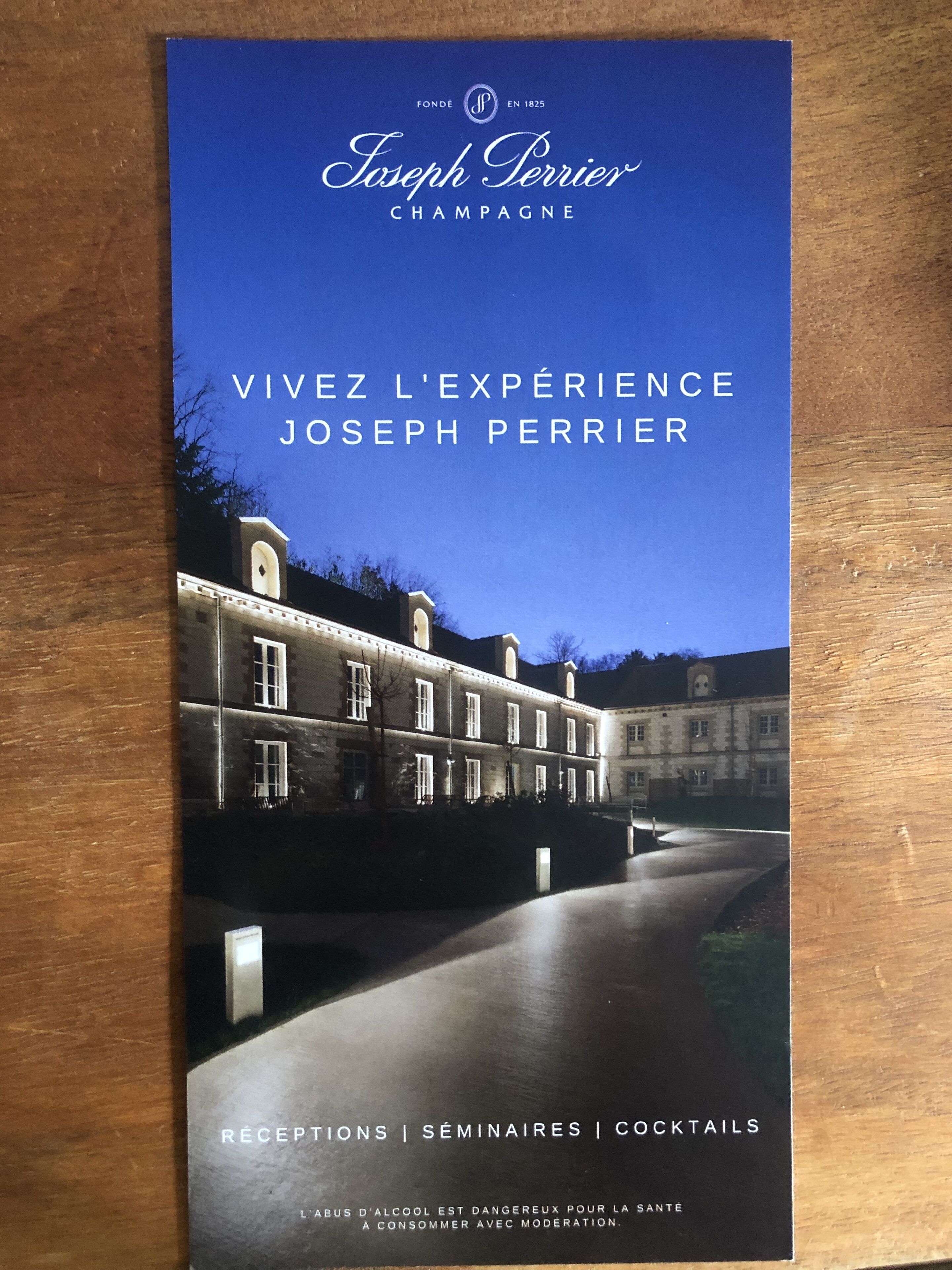 Eine Broschüre für Joseph Perrier Champagner mit einem Foto eines Gebäudes bei Nacht.