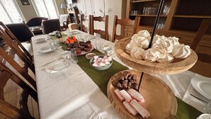 A dining table set with plates, glasses, and various food items.