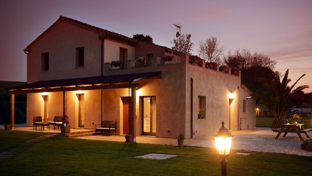 Une maison à deux étages dotée d’un patio couvert, d’une petite piscine et d’une entrée bien éclairée.