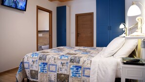A bedroom with a bed, a TV mounted on the wall, and a bedside table with a lamp. - Montefiore House 13 - Iris Farmhouse in the Marche countryside (Marche)