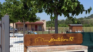 Ein Holzschild mit der Aufschrift 'Monteforte 13', das auf ein Gebäude oder einen Ort hinweist.