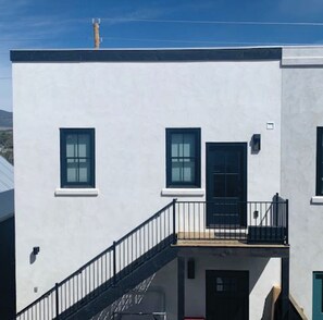 Stylish building with a flat facade, featuring a ground-floor balcony and two windows.