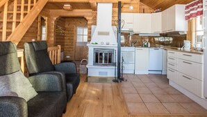 L’intérieur d’un chalet confortable, avec une cheminée, un coin repas et une cuisine.