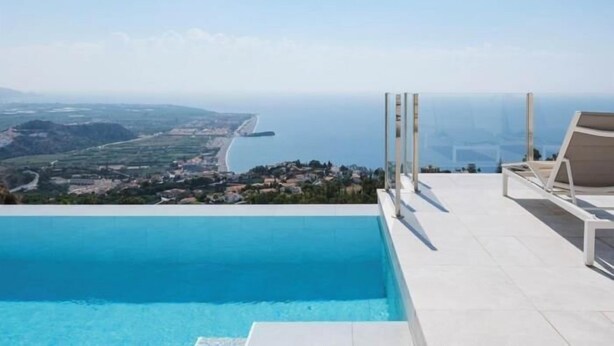 Vista despejada de una piscina con vistas a la costa y colinas distantes.