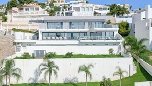 Un edificio moderno de varios pisos con tejado plano, ventanas amplias y fachada plana.