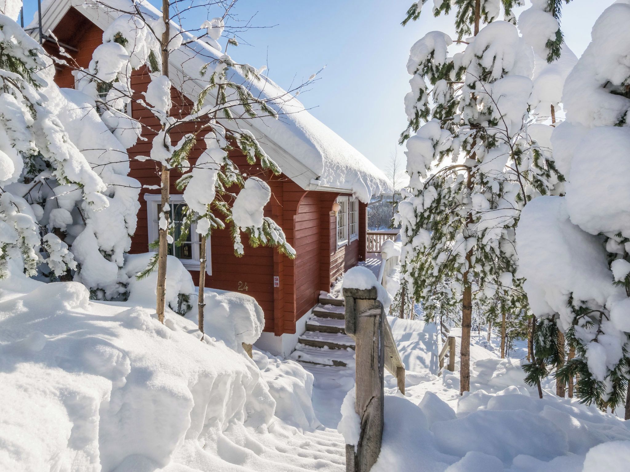 A wooden cabin surrounded by snow-covered trees.