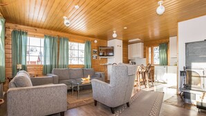L’intérieur d’un chalet confortable, avec un salon, un coin repas et une cuisine.