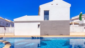 Un bâtiment moderne de couleur blanche avec une piscine à l’avant.