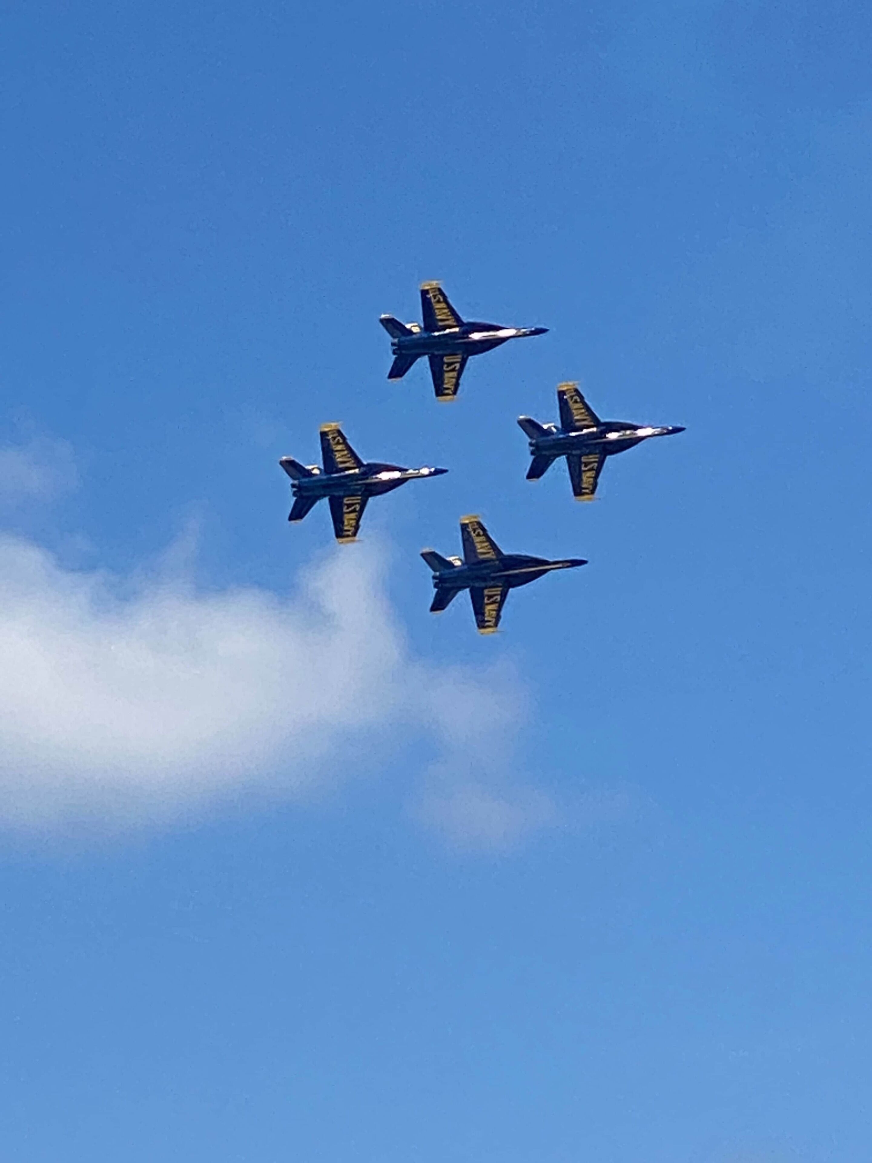 Four aircraft flying in formation against a clear blue sky.