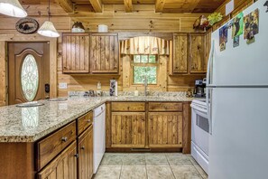 A kitchen with wooden cabinets, a granite countertop, a built-in oven, and a refrigerator. - MoreDISCOUNTS🌄
COZY PEACEFULSeclusionCLOSE to FUN 2BR+Loft 170+ 5 star Reviews (Sevierville)