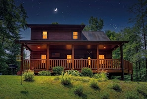 A two-story log cabin with a porch, surrounded by a grassy yard and trees. - MoreDISCOUNTS🌄
COZY PEACEFULSeclusionCLOSE to FUN 2BR+Loft 170+ 5 star Reviews (Sevierville)