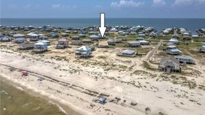 An aerial view of a coastal residential area with houses, some on stilts, and a beach in the foreground. - Gulf Front - 5BR - 2BA - 120 Steps to Beach! (Dauphin Island)