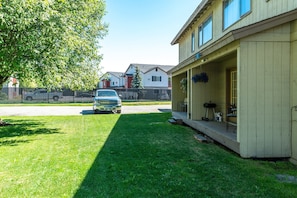 A residential building with a porch, a lawn, and a parked vehicle. - The Moose Crossing : Close to Airport, Centrally Located with Garage (Anchorage)