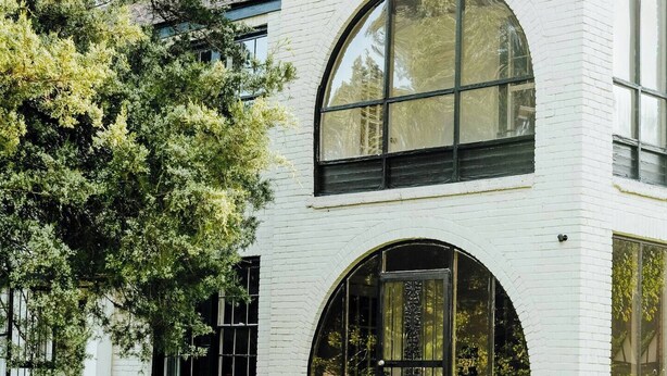 A modern white brick house with a large arched window and a well-maintained lawn. - Chic 2BR Stay | Cozy Living & High-Speed WiFi (Montgomery)