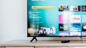 A flat-screen TV mounted on a wooden cabinet with a Roku interface displaying various streaming services. - Chic 2BR Stay | Cozy Living & High-Speed WiFi (Montgomery)