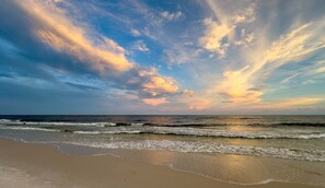 Una spiaggia con onde e cielo nuvoloso.