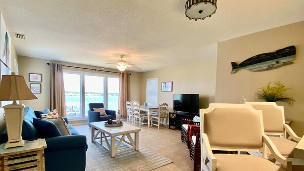 A living room with a sofa, a coffee table, a TV, and a dining area.