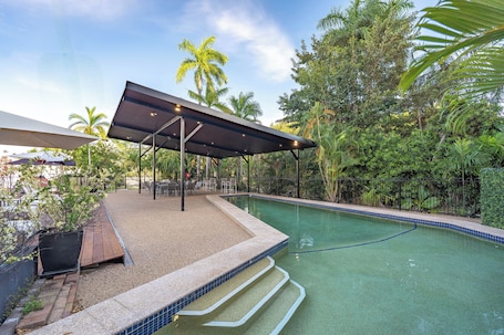 Una piscina al aire libre, sombrillas, sillones reclinables de piscina. Vitina Studios by Argus