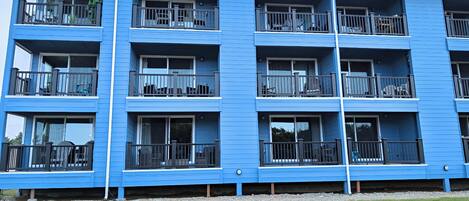Un immeuble bleu à plusieurs étages, doté de balcons, de fenêtres et de cheminées.