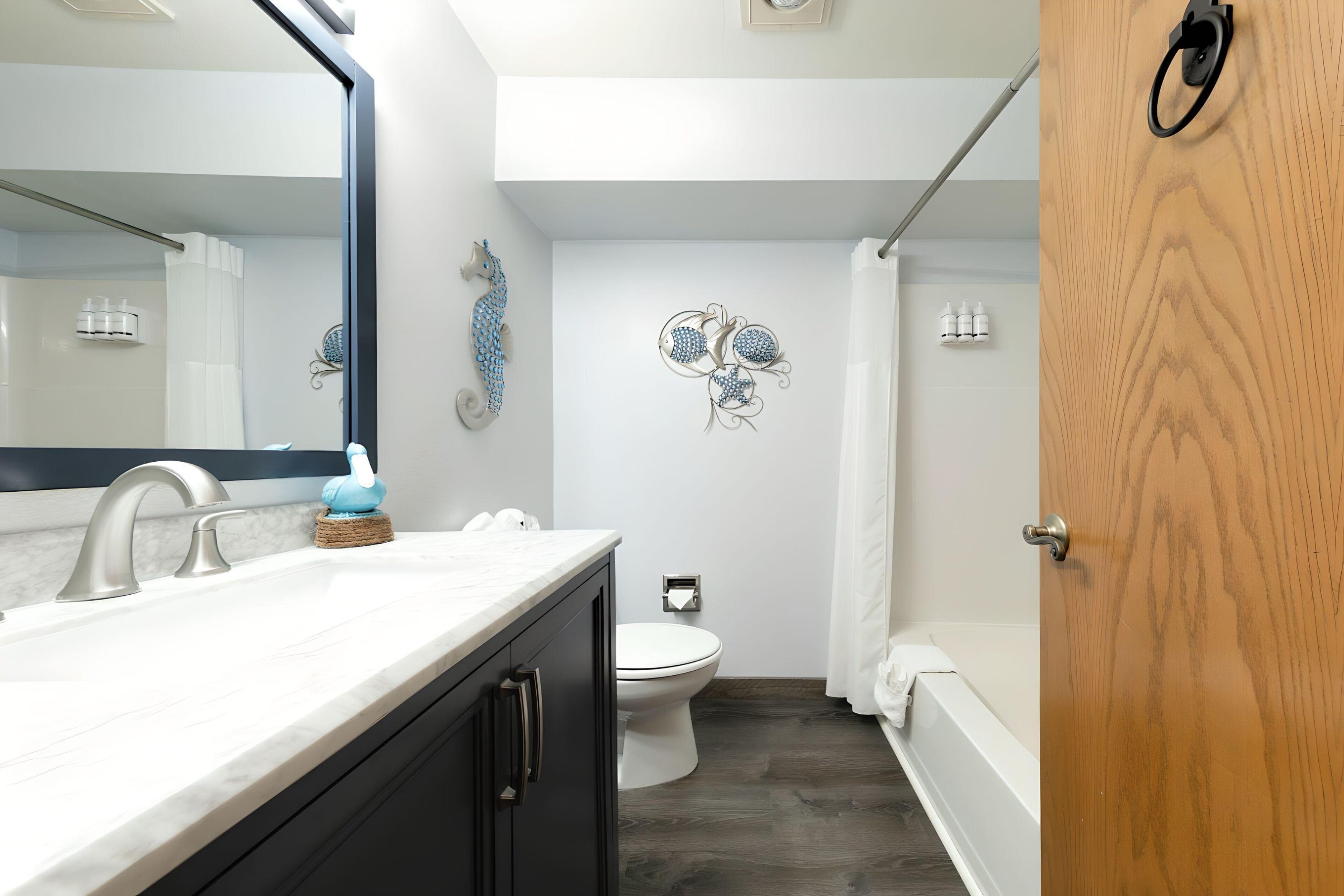A bathroom with a white sink, a toilet, and a bathtub.