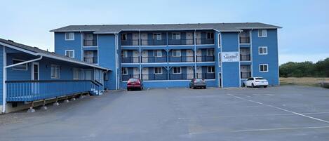 Un motel azul con un área de estacionamiento central, varios balcones y un letrero que dice 'The Nautilus'.