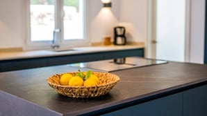 Una encimera de cocina con una cesta tejida que contiene limones y hojas de menta.