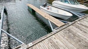 Eine Holzsteganlage mit nummerierten Pfählen, Boote liegen am Kai festgemacht, und ruhiges Wasser.
