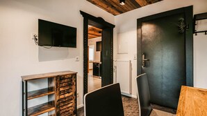 A modern interior with a wooden cabinet, a black chair, and a black door. - Ferienwohnung - Wagrain (Wagrain)