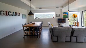 A modern living space with a dining area, a large window with a view, and a sofa. - Villa Croix Valmer / Gigaro, air-conditioned, beach on foot with heated swimming pool (La Croix-Valmer)