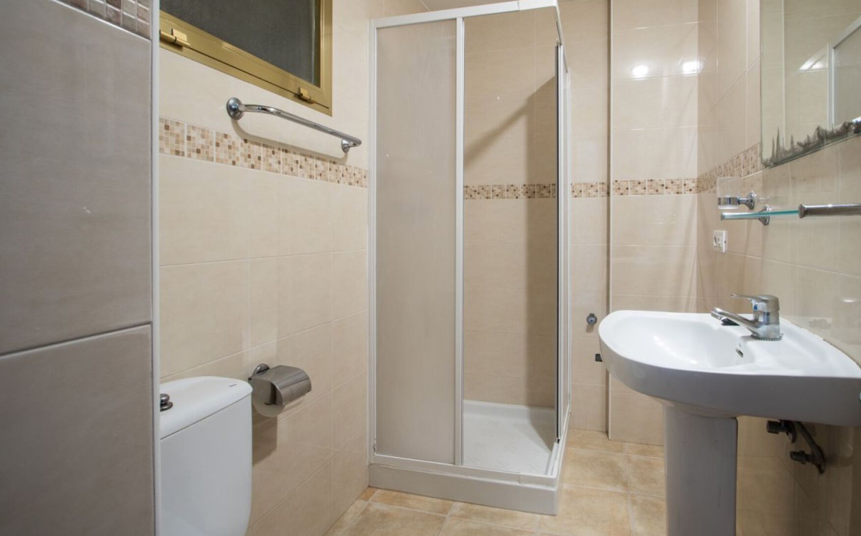 Un baño con ducha, inodoro y lavabo.
