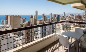 Enjoy a city view from this balcony with a table and chairs for dining or relaxation.