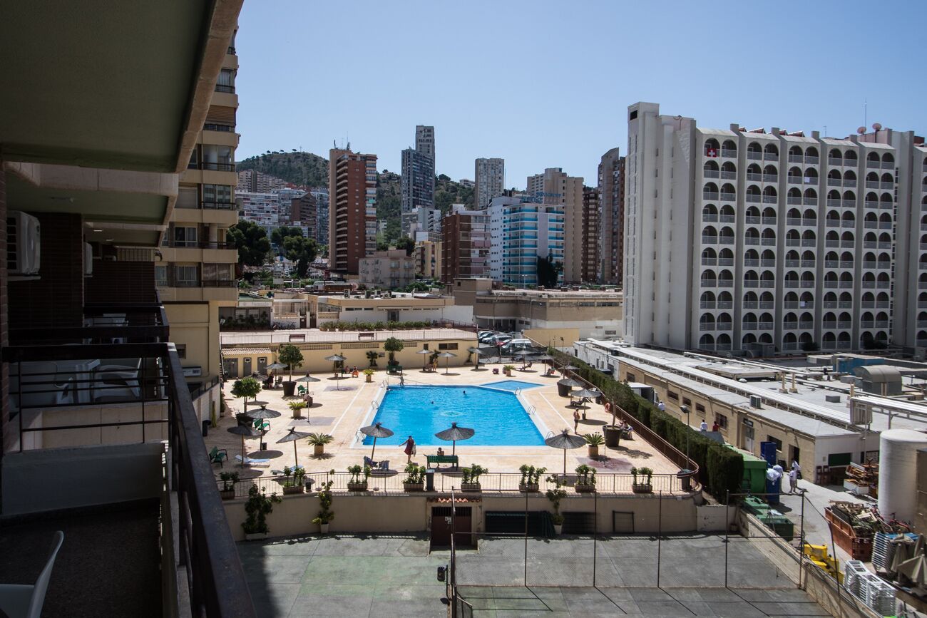 Une piscine sur le toit, entourée d’espaces de détente et avec une vue sur le paysage urbain en arrière-plan.
