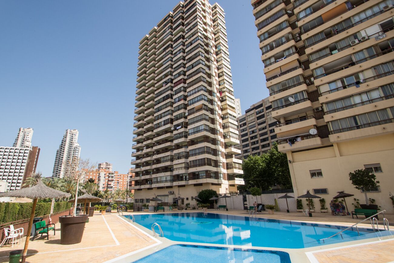 A high-rise residential building with a swimming pool area.