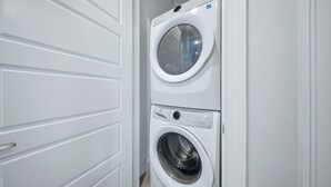 A laundry room with two stacked washing machines. - Upscale Villa with Home Theater at Reunion (Kissimmee)