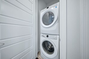 A laundry room with two stacked washing machines. - Upscale Villa with Home Theater at Reunion (Kissimmee)