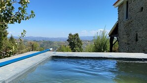 Um edifício de pedra com piscina e vista para o campo.