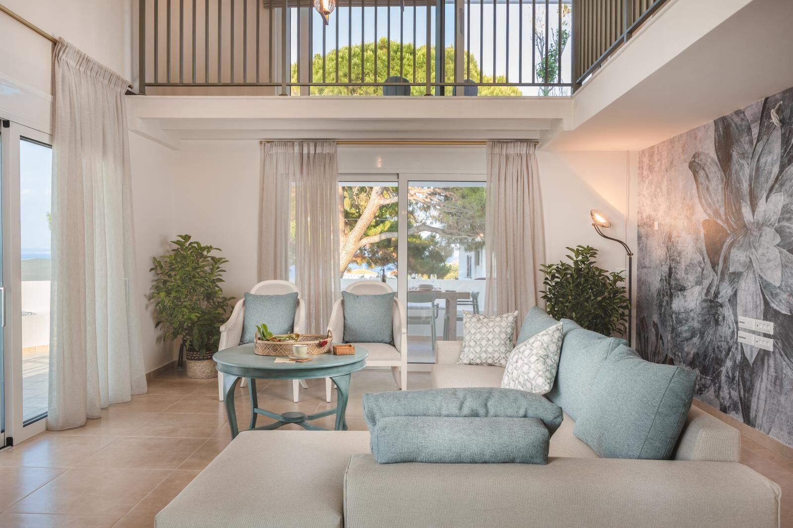 Un salon spacieux avec un plafond haut, un balcon et une vue sur l’extérieur.