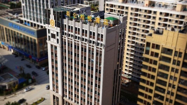 A high-rise building with multiple balconies and a rooftop garden. - Melody Hotel (Longyan)