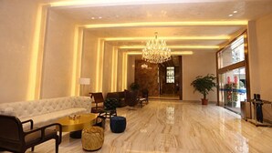 A spacious lobby with a chandelier, seating area, and a large window. - Melody Hotel (Longyan)