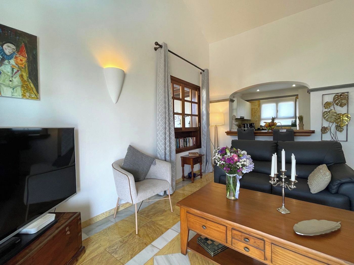 A living room with a TV, a sofa, a coffee table, and a bookshelf.