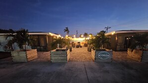 A hotel entrance with a paved driveway, palm trees, and a sign reading "Starfish Stay Cape Coral."