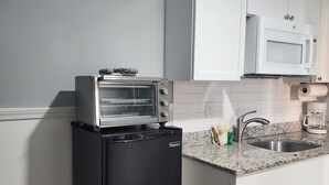 A compact kitchen with a built-in toaster oven, a microwave, and a sink. - Harrison Hotel Unit D
Pet Friendly 
Ground Level Unit (Garden City Beach)