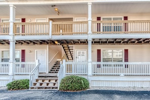 Stunning two-story building with a central staircase and balconies on each floor, offering a charming entrance.
